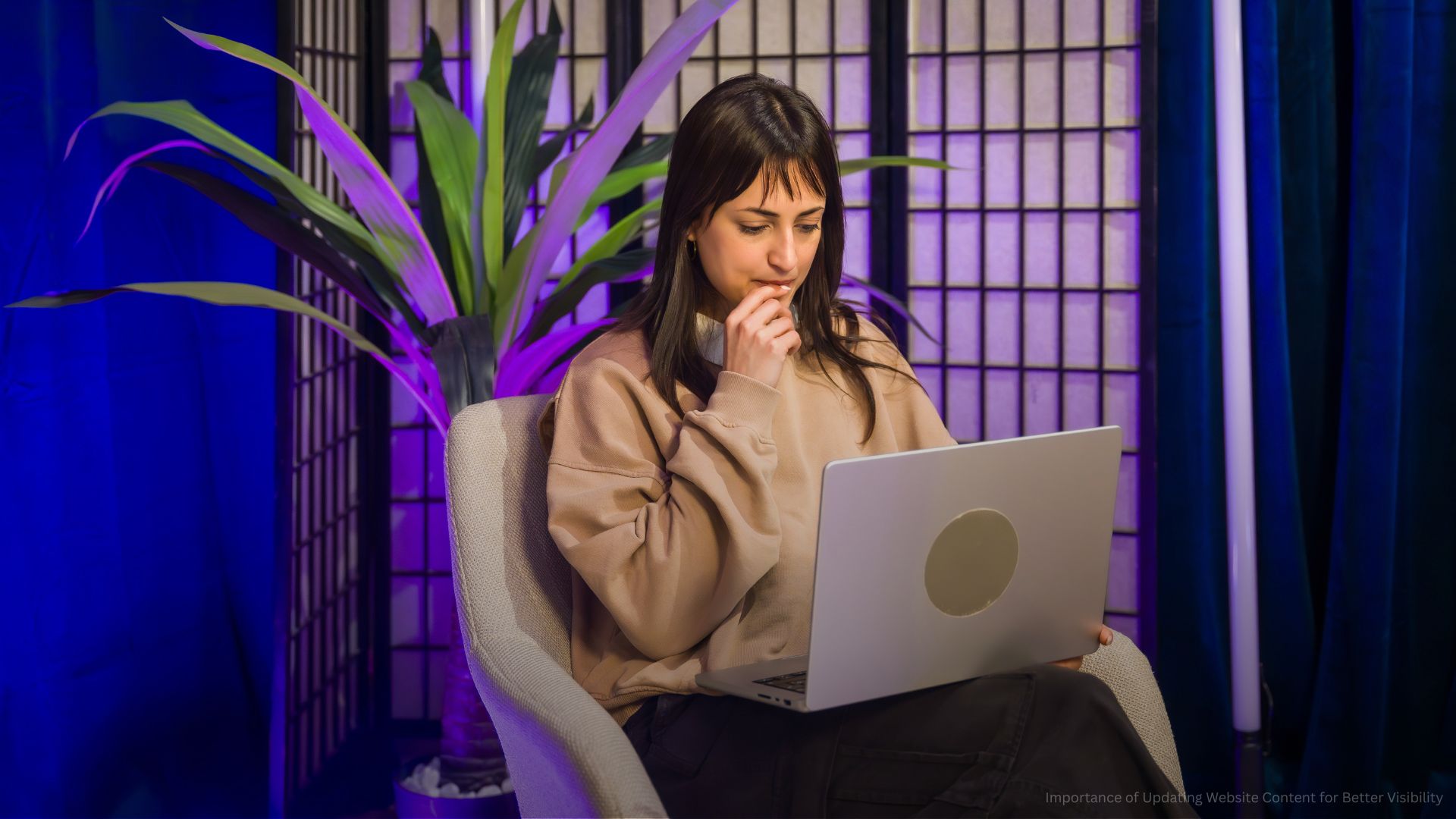 Woman content creator working on laptop in studio